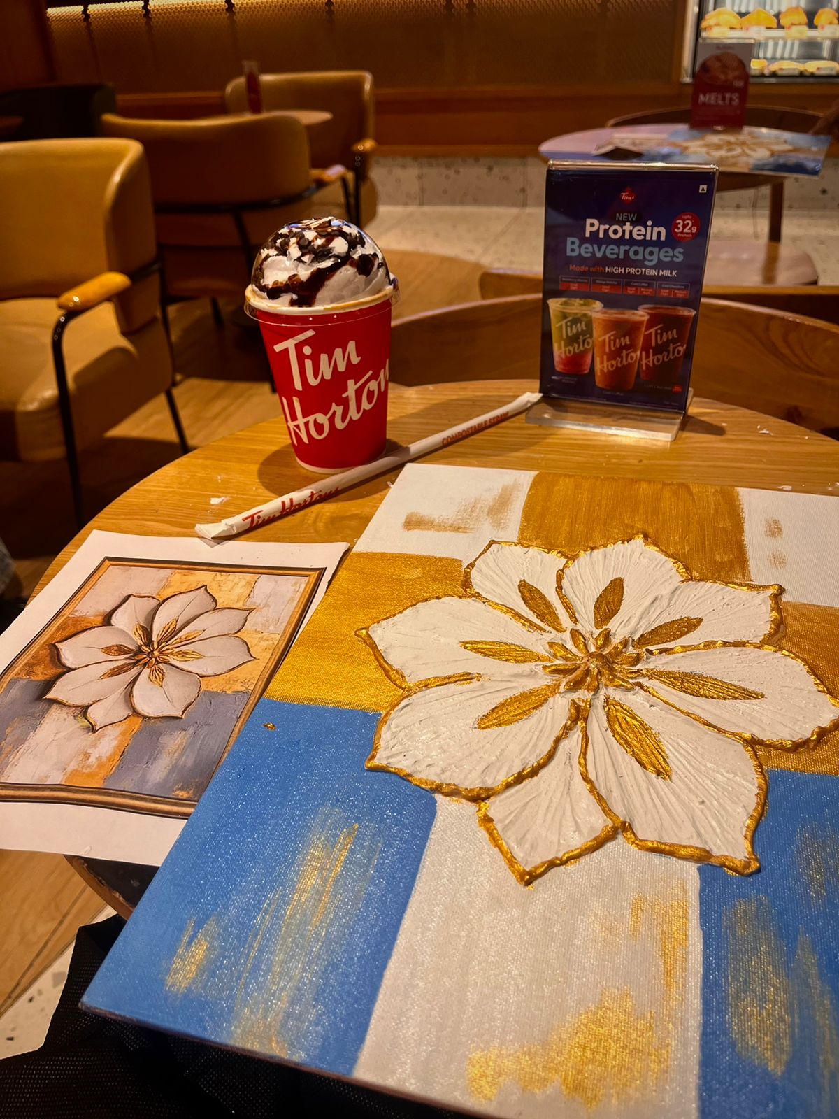 Gold flower painting at a cafe table