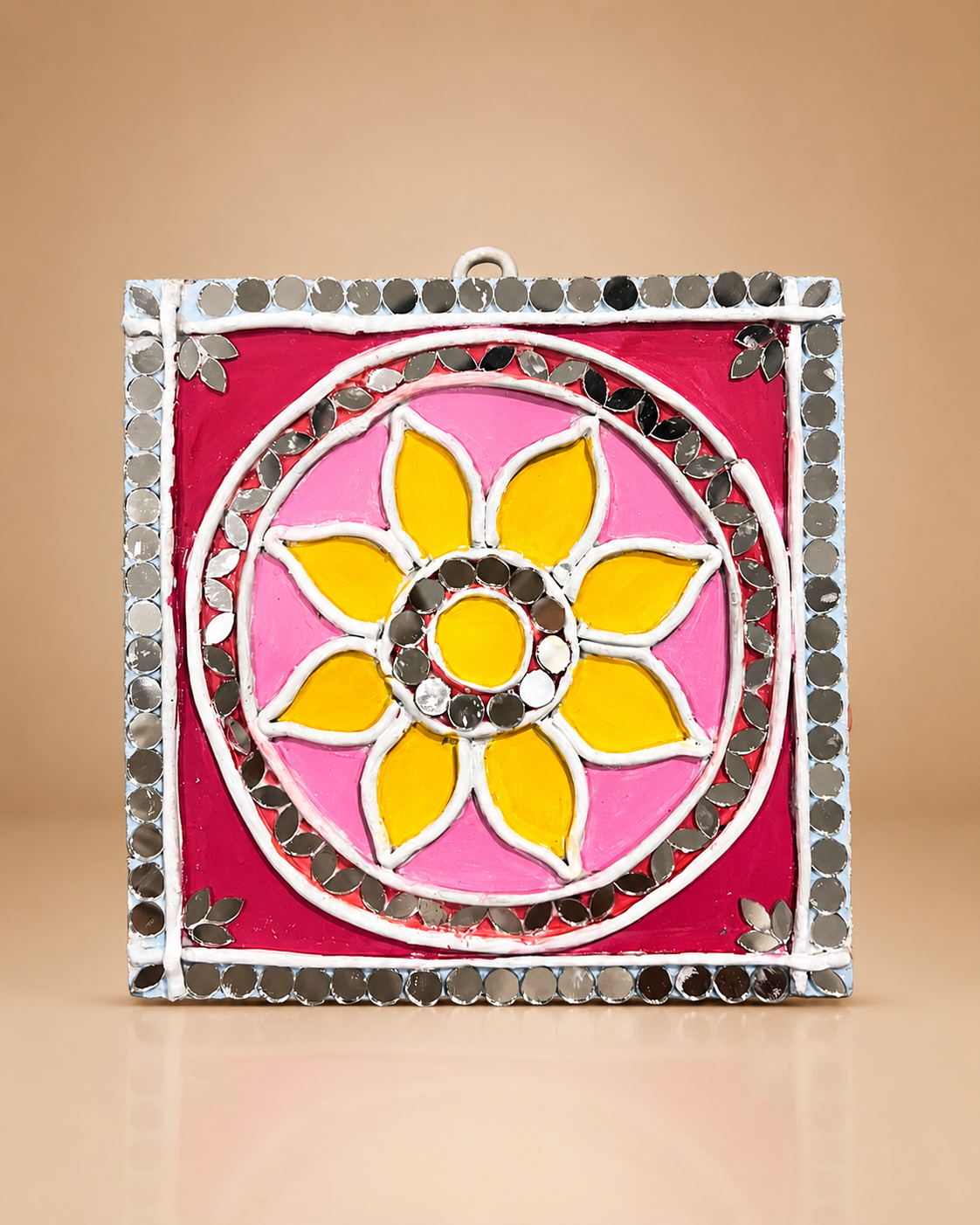 A finished saffron and rose Lippan mandala with a mirror border